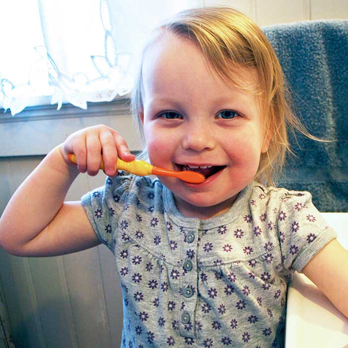 Little cute girl brushing her teeth