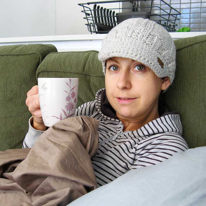 Woman having coffee while lying on sofa